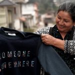 A woman holding a sustainabily made jumper